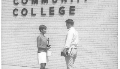 early promotional photo, young man and young woman standing in front of building with GCC title